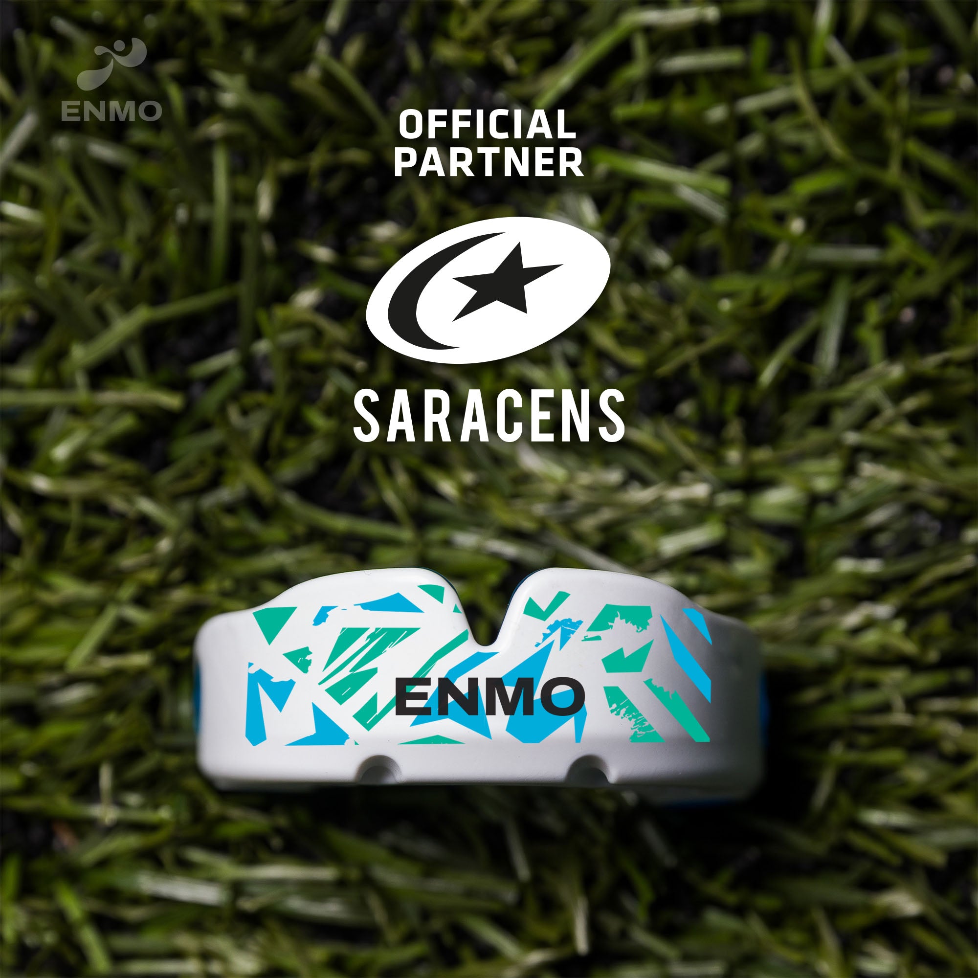 An Enmo Maxilla Pro Mouthguard in a fusion white and blue colour on a grass background with Saracens logo