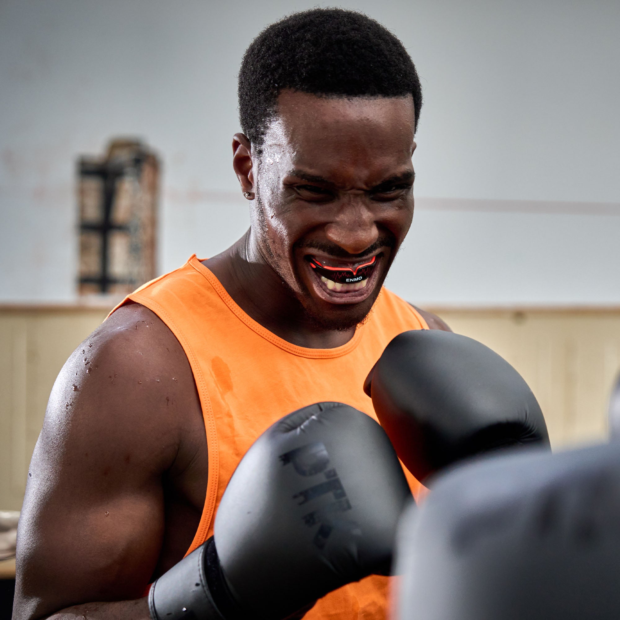Boxer wearing red and black gum shield whilst boxing.